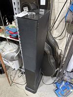 Full view of tall black Brookstone tower speaker standing on floor
