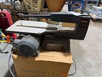 Full view of Craftsman scroll saw on box showing table, motor housing and power cord