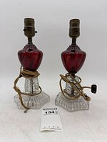 Full view of both cranberry glass lamps with cords and size reference
