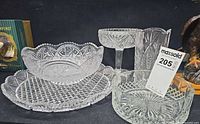 Group shot of all five cut glass pieces including platter, bowl, compote, vase and low bowl