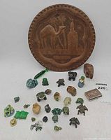 front view of metal tray and grouping of frog figurines and wood elephant