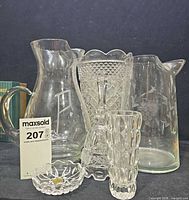 Group shot showing both etched pitchers, cut glass vase, slim vase, bell, trinket dish