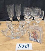 Lot overview showing candlestick, Kosta Boda sculpture, champagne flutes and stemware