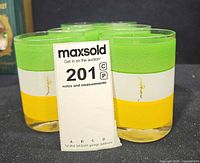 Front view of six green, white and yellow striped Morgan glasses