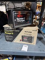 Charger on top of original box showing front label with specs