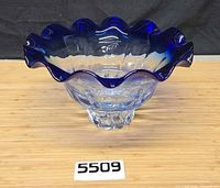 Angled view showing cobalt ruffled rim and pedestal foot