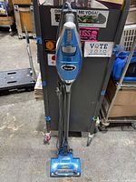 Full view of blue Shark corded stick vacuum standing upright