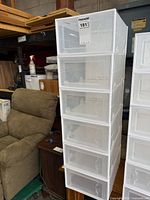 front view of six stacked plastic shoe boxes showing clear doors and white frames