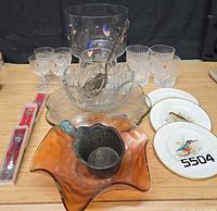 Assortment of glassware, spoons, plates and pan iron displayed on table