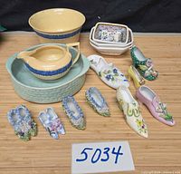 Full lot showing all bowls, creamer and eight shoe figurines
