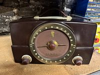 Front view of brown Zenith H725 radio showing dial, speaker grille, knobs, handle