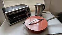 Toaster oven, kettle, sauté pan with lid grouped together