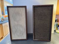 Front view showing both speakers with different grill cloth colours