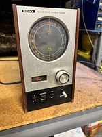 Front angled view showing wood cabinet, circular dial, controls