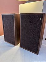 Front view of both Utah speakers showing grille cloth and wood cabinets