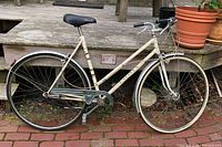 Left side view of complete Batavus cream step-through bicycle showing frame, wheels, fenders, chain guard