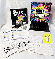 Contents displayed: rulebook, pencils, target sheets, answer pads, cards, inner tray