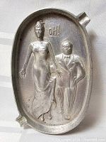 Front view showing full ashtray and relief figures