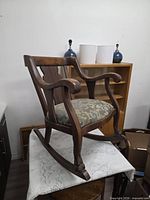 Full side view of wooden rocking chair on table