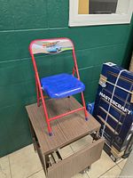 full view of child folding chair on stand, shows frame and seat