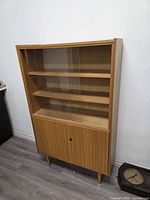 Full view of china cabinet showing glass doors, wood frame, legs