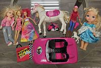 All dolls, horse, car, motorcycle, unicorn and tote arranged on floor