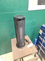 Full view of black Honeywell tower heater on table