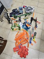 Top view of full assortment spread on floor showing tracks, tower, spaceship base, dinosaur parts, accessories