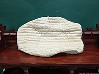 quilted cream air conditioner cover on wooden bench
