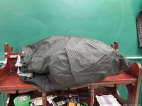 Kayak cover inside black mesh carry bag on shelf