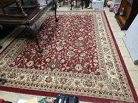 Full view of red Kashan area rug under furniture