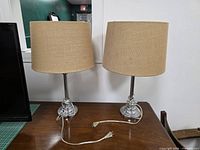 Front view of both chrome table lamps with shades and cords visible