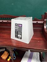 Front view of white square lamp shade with label visible