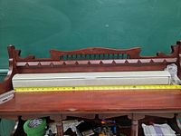 Roller shade in cassette shown on shelf with tape measure for width context