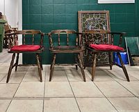Front view of three wooden chairs showing design and cushions