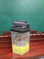 Full view of aquarium tank showing hood, filter, and gravel