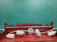 Full view of curved metal track light with four frosted glass shades on wood surface