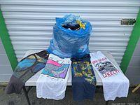 Bag of assorted T-shirts with four sample shirts displayed