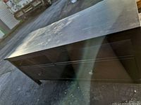 Front and top view showing two drawers, black laminate finish, surface wear