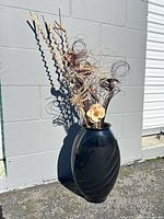 Full view of black floor vase and dried arrangement