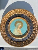 Front view of ornate round frame and Virgin Mary print