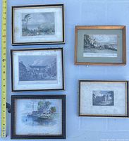Overview of five framed engravings laid out with measuring tape for scale