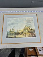 Front view of framed seascape reproduction print with ships, harbor, grey mat and gold frame