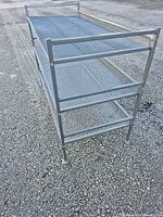 three-tier gray metal mesh shelving unit angled view