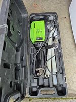 Open carry case showing jackhammer, power cord and two chisel bits