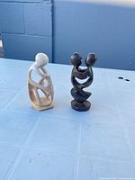 Front view of both soapstone figurines, showing overall form and color contrast