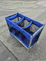 Full view of blue 3-bin laundry sorter on metal frame