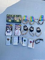 All 12 packaged jewellery pieces laid out—copper cuffs, cord bracelets, gemstone stretch bracelets, Heartstone heart pendants