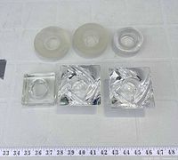 Top view of all five glass candle holders arranged on surface with ruler for scale