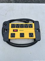 Full view of NOMA surge protector showing eight outlets and coiled cord